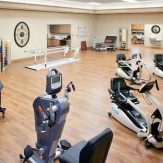 A spacious fitness center equipped with various exercise machines for rehabilitation and workouts.