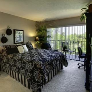 A well-decorated bedroom featuring a large bed, stylish decor, and a desk by the window.