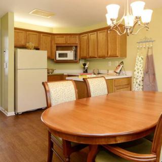 A cozy home kitchen with a wooden dining table and modern appliances.