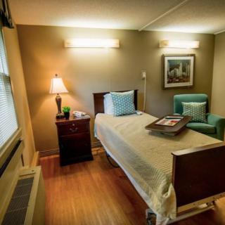 A cozy hospital room with a single bed and comfortable seating.