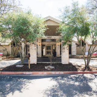 A welcoming entrance surrounded by trees, leading into a charming building.