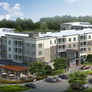 A modern apartment complex with landscaped grounds and adjacent parking facilities.