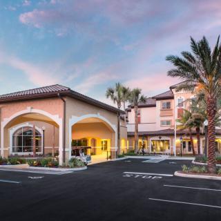 A welcoming hotel entrance at sunset, framed by palm trees.