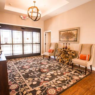 A welcoming lobby area featuring elegant chairs, a decorative rug, and tasteful artwork.