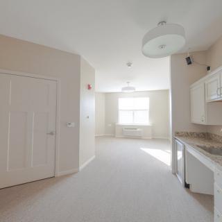 A bright and empty minimalist kitchen and living space.