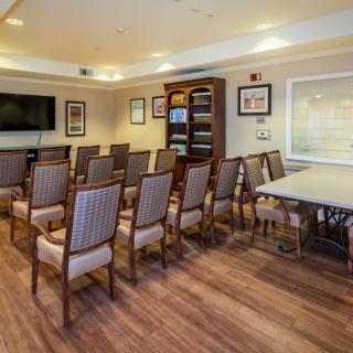 A neatly arranged conference room with chairs facing a television, ready for a presentation or meeting.