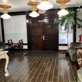 A modern lobby featuring elegant lighting, stylish furniture, and decorative plants.
