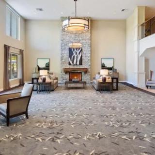 A spacious lobby with a cozy seating area, chandelier, and fireplace.