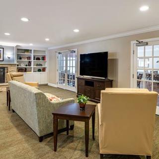 A cozy living room with comfortable seating, a large TV, and built-in shelves.