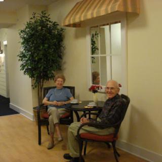 Two elderly individuals enjoying their time in a cozy lounge area.