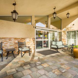 A welcoming entrance with outdoor seating and decorative lanterns.