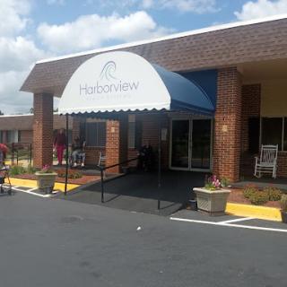 The welcoming entrance of a hospitality establishment under a blue awning.
