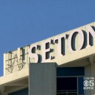 A hospital building with prominent signage under a clear blue sky.