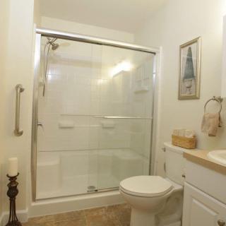 A modern bathroom with a glass-door shower and neatly arranged amenities.
