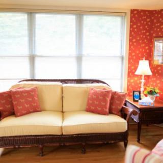 A cozy living room with a comfortable sofa, vibrant cushions, and warm lighting.