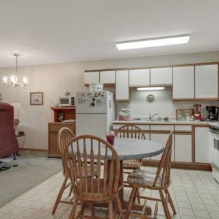A cozy kitchen with a dining area featuring a table, chairs, and basic appliances.