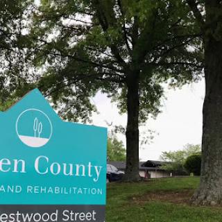 A sign for a rehabilitation facility surrounded by trees.