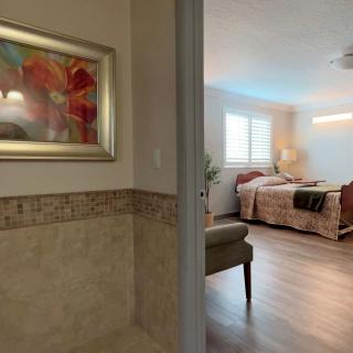 A modern bedroom with a decorative painting on the wall and stylish furnishings.
