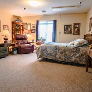 A cozy bedroom with comfortable seating and warm decor.