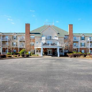 The exterior of a hotel with a large entrance and multiple windows against a clear blue sky.