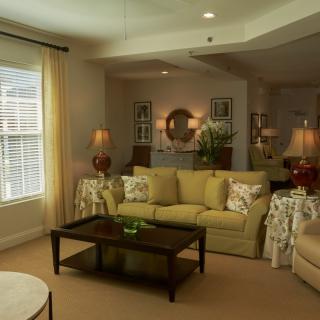 A cozy living room with stylish decor, featuring a sofa, coffee table, and elegant lighting.