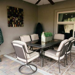 A cozy outdoor patio area with a dining table and six cushioned chairs.