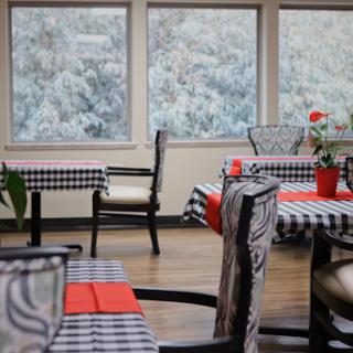 A cozy dining area featuring checkered tablecloths and a scenic window view.