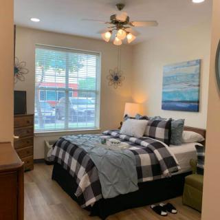 A cozy bedroom with a neatly arranged bed, stylish decor, and large window.