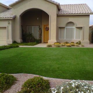 A well-maintained residential home with a lush front lawn and landscaped garden.