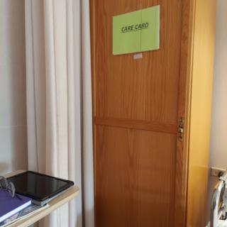 A wooden door labeled 'CARE' in a well-lit interior space.