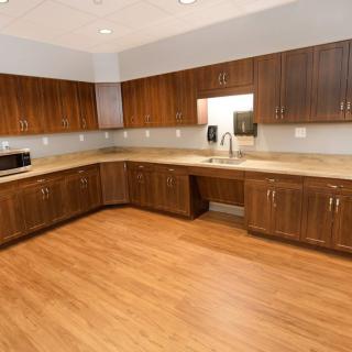 A modern kitchen with wooden cabinets, countertops, and wood flooring.