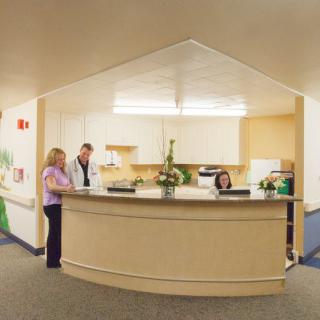 A receptionist area with people interacting at the desk.