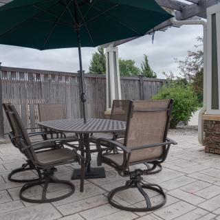 A cozy patio setup with a round table, chairs, and a large umbrella.