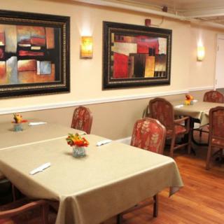 A cozy restaurant interior with tables and artwork on the walls.