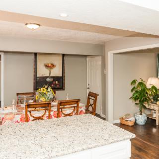 A cozy dining area with a table set for a meal and decorative elements including flowers and plants.