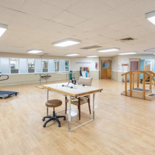A spacious physical therapy room equipped for rehabilitation exercises.