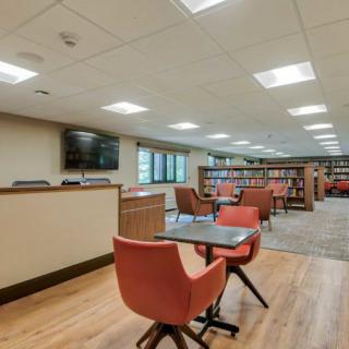A modern library interior with seating and bookshelves.