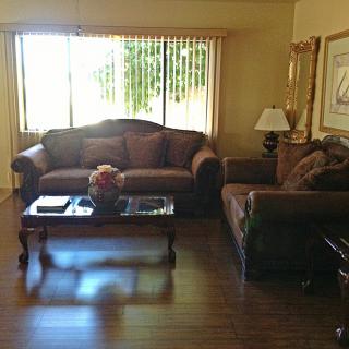A cozy living room with two sofas, a coffee table, and a lamp by the window.