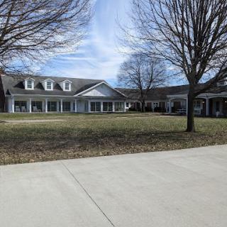 A spacious residential property with a well-maintained front yard and clear blue skies.