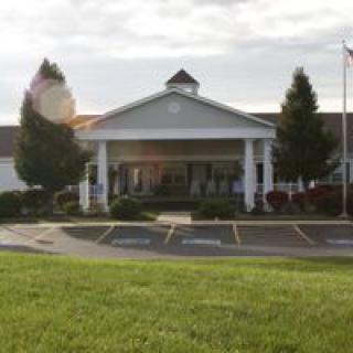 A symmetrical building entrance with a covered driveway and adjacent parking spaces.