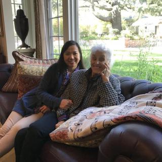 Two people sitting on a couch in a cozy living room.