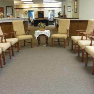 A waiting room with chairs arranged in a circle around a small table.