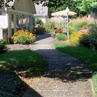 A scenic garden pathway surrounded by vibrant flowers and lush greenery.
