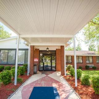 Entrance to a building with a covered pathway and landscaped garden.