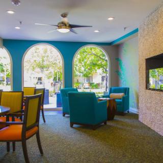 A modern, colorful lounge area with comfortable seating and large windows.