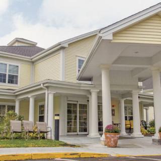 A residential building with a covered entrance and decorative columns.