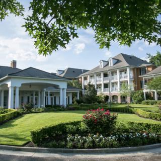 A luxurious hotel with classic architecture surrounded by lush greenery.