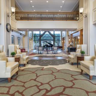 A luxurious hotel lobby featuring elegant seating and a grand piano.
