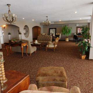 A spacious lobby with comfortable seating, elegant chandeliers, and decorative plants.