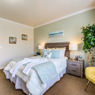 A cozy, modern bedroom with a neatly made bed, stylish decor, and soft lighting.